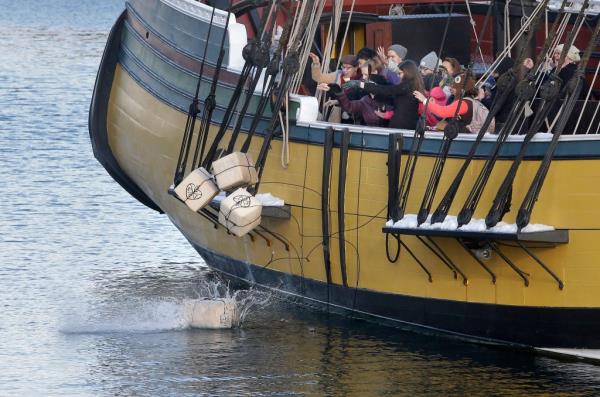 Visitors to the Boston Tea Party Museum throw replica tea co<em></em>ntainers into the Boston Harbor from one of the replica boats on Dec. 11, 2017.