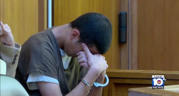 Rosa in court, wearing prison garb, with his head in his hands. 