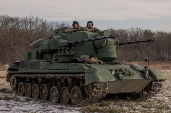 Three Ukrainian soldiers traveling in a tank.