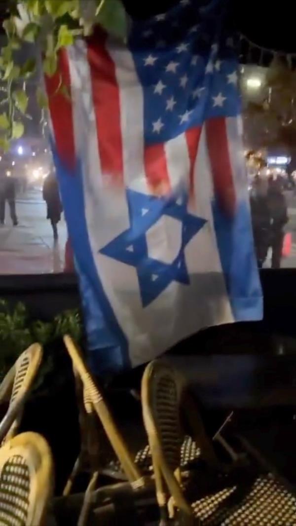 A well-dressed woman targeted this blended Israel/US flag at the Hummus Kitchen cafe on the Upper East Side.