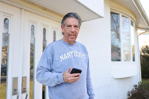 barry pollack, with cell phone in hand, outside the jericho home