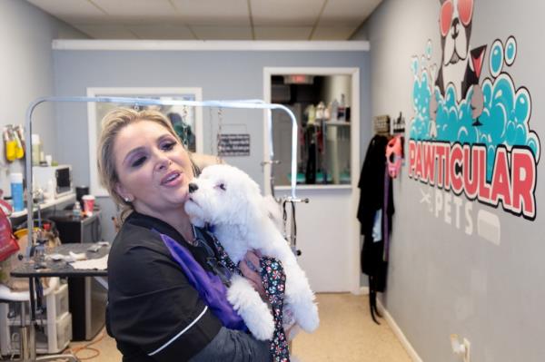 Dog groomer Joanne Wilson with a "client" at her store Pawticular Pets