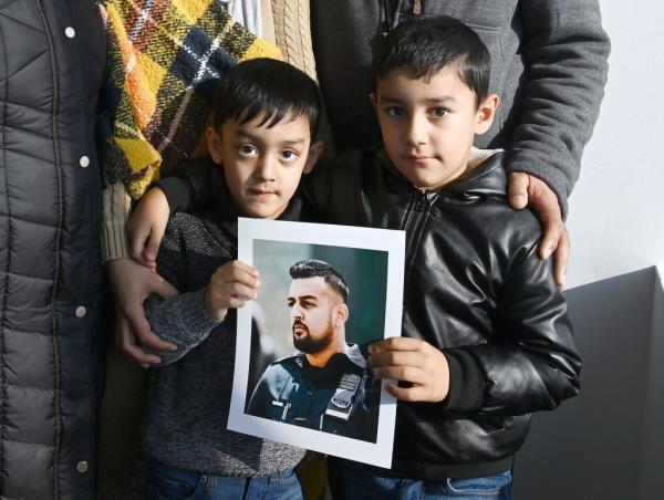 Slain officer's sons Zayaan, 4, and Rayaan, 5, hold a large photo of Fayaz in uniform at the Police Benevolent Association office in Lower Manhattan.