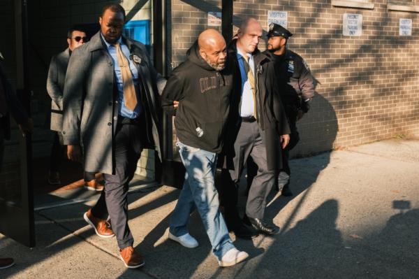 Danny Daniel is walked from the 81st precinct to a NYPD vehicle en route to Brooklyn Criminal Court. 